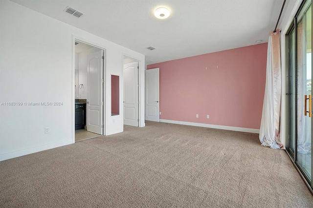 unfurnished bedroom with light carpet and ensuite bath