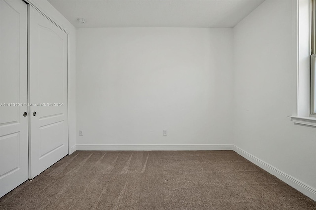 unfurnished bedroom featuring carpet and a closet