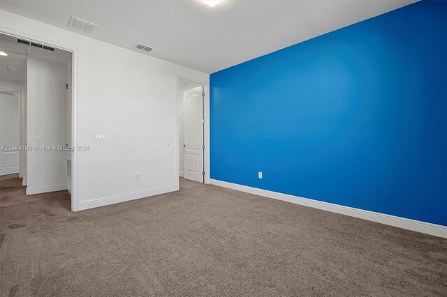 unfurnished bedroom featuring carpet and a textured ceiling