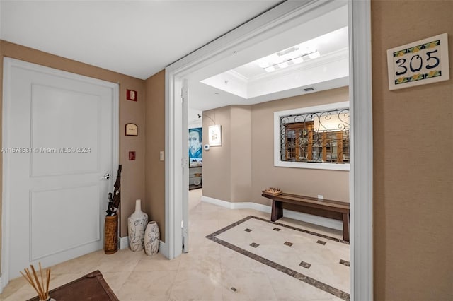 foyer with crown molding and a raised ceiling