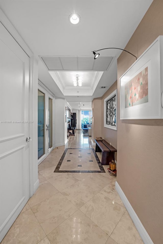 hallway featuring crown molding and a tray ceiling