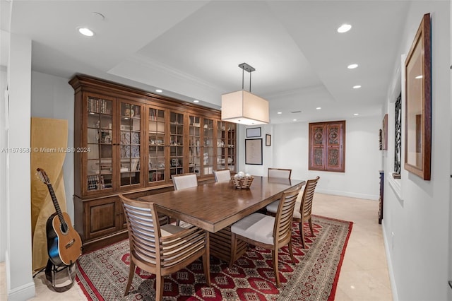 tiled dining room featuring a raised ceiling