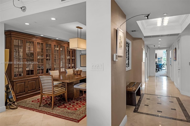 dining area with crown molding, light tile patterned flooring, and a tray ceiling