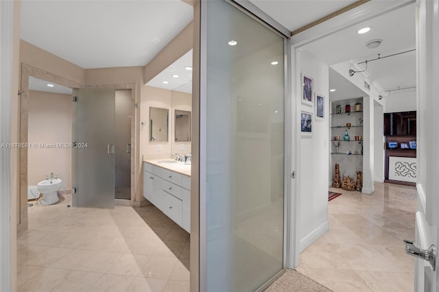 bathroom with vanity, a shower with shower door, and a bidet