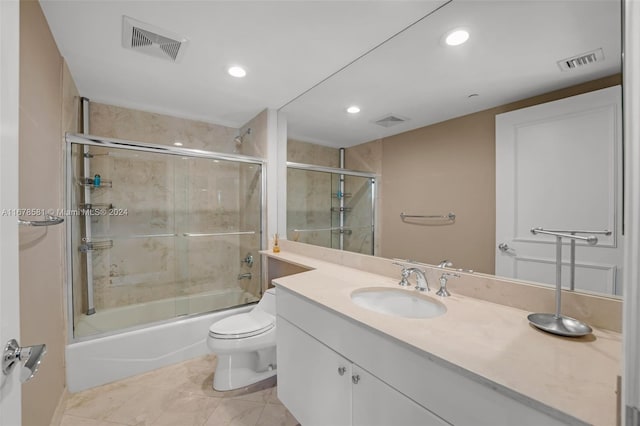 full bathroom featuring vanity, bath / shower combo with glass door, and toilet