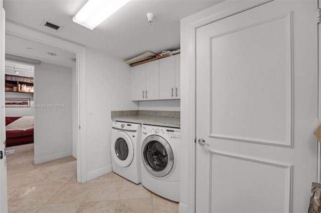 laundry room featuring cabinets and separate washer and dryer