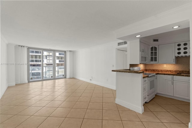 kitchen with crown molding, white appliances, decorative backsplash, light tile patterned floors, and glass insert cabinets