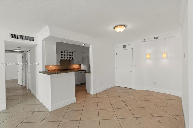 kitchen with tasteful backsplash, light tile patterned flooring, pendant lighting, white cabinets, and crown molding