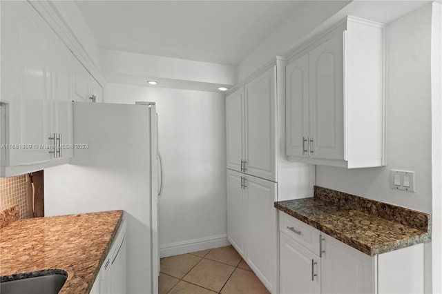 kitchen featuring white appliances, dark stone counters, white cabinetry, recessed lighting, and light tile patterned floors