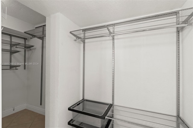 walk in closet with tile patterned flooring