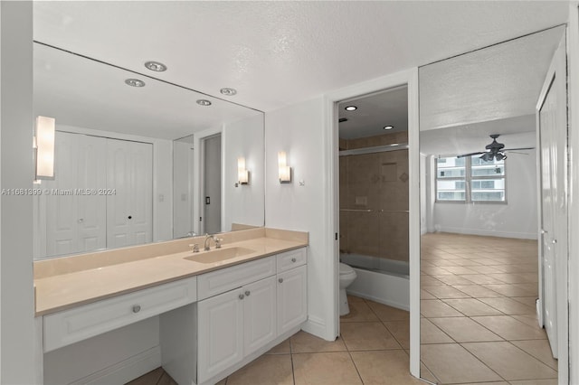 bathroom with a ceiling fan, tile patterned floors, vanity, toilet, and  shower combination