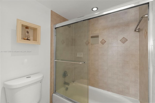full bath featuring combined bath / shower with glass door and toilet