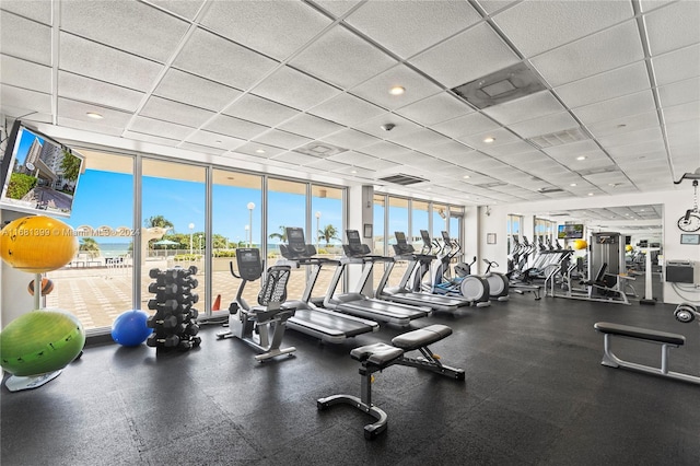 workout area featuring expansive windows, recessed lighting, and a drop ceiling