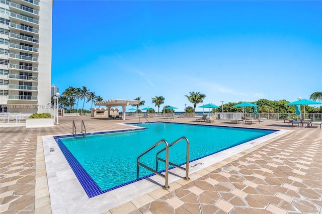 community pool with fence and a patio