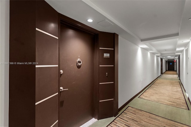 corridor featuring recessed lighting, baseboards, and light colored carpet