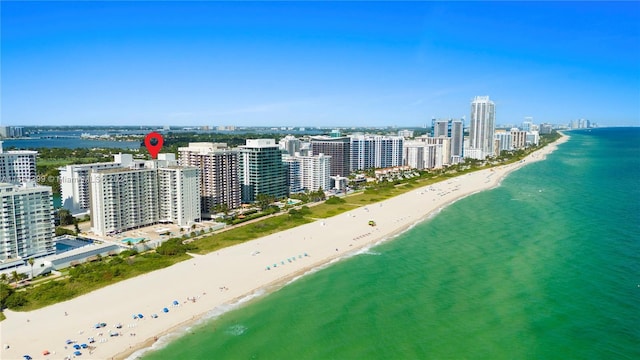 aerial view featuring a beach view, a water view, and a view of city