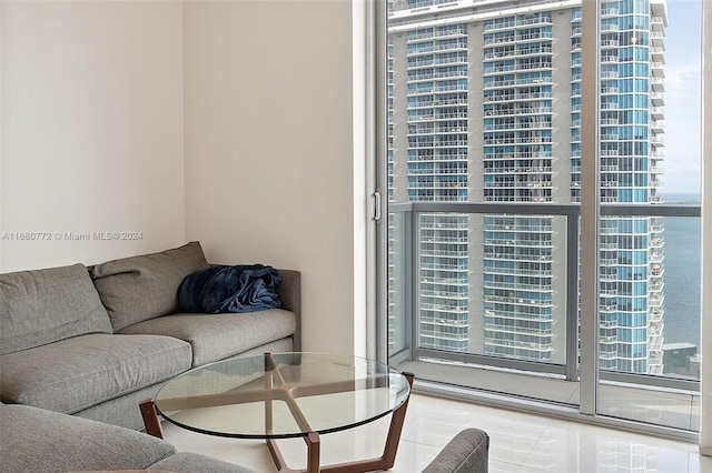 living room with a water view, tile patterned floors, and plenty of natural light