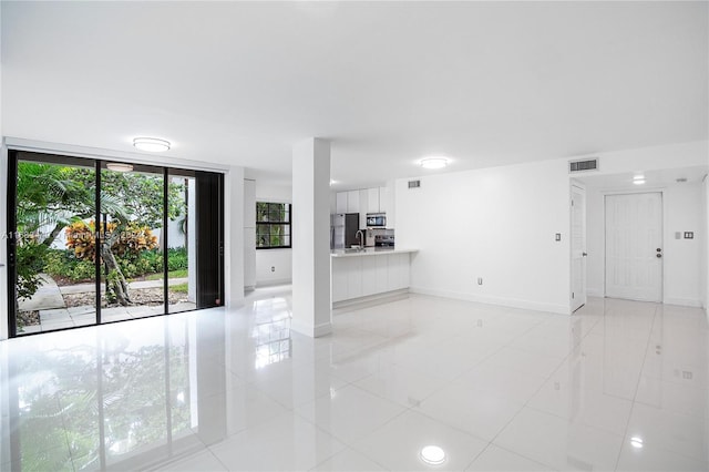 unfurnished living room with sink and light tile patterned floors