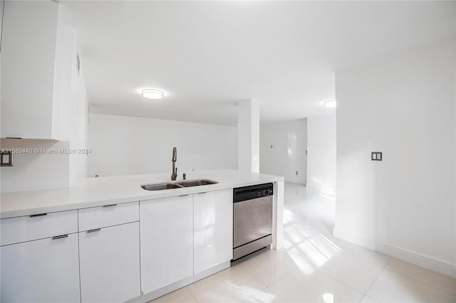 kitchen featuring kitchen peninsula, white cabinets, light tile patterned floors, dishwasher, and sink