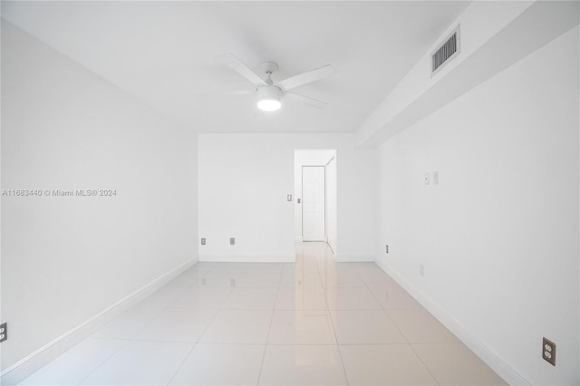 spare room with ceiling fan and light tile patterned floors