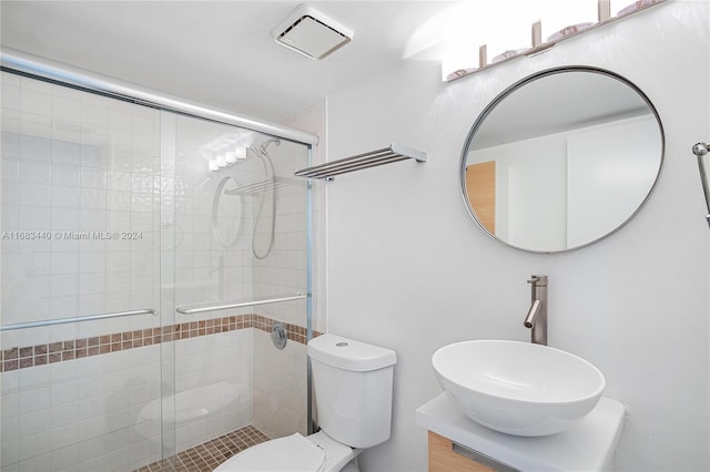 bathroom with toilet, a shower with shower door, and vanity