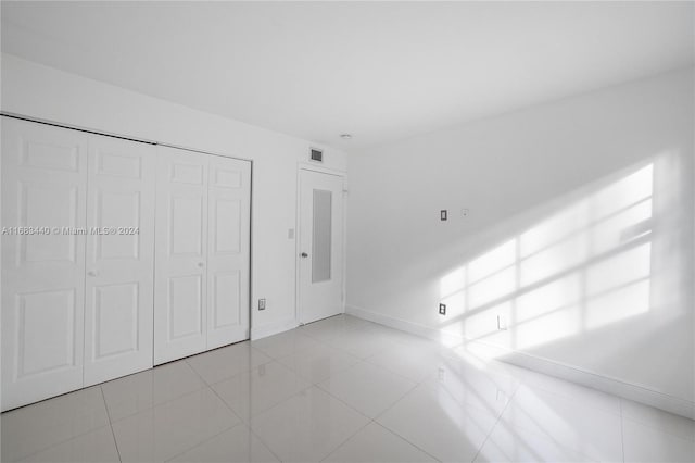 unfurnished bedroom featuring a closet and light tile patterned flooring