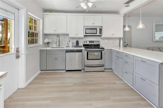 kitchen featuring gray cabinetry, stainless steel appliances, sink, and kitchen peninsula