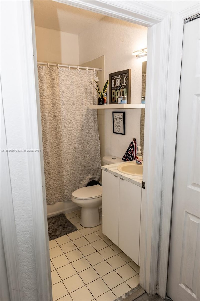 bathroom with vanity, walk in shower, tile patterned floors, and toilet