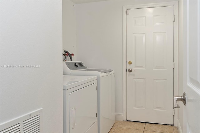 laundry area with light tile patterned flooring and separate washer and dryer