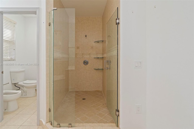 bathroom featuring toilet, tile patterned floors, a shower with shower door, and a bidet