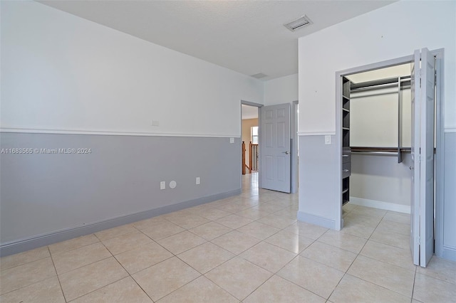 unfurnished bedroom featuring a closet and light tile patterned floors