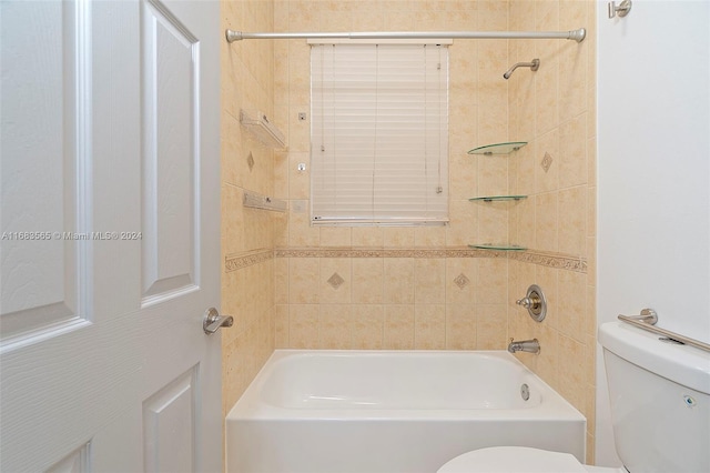 bathroom with tiled shower / bath and toilet