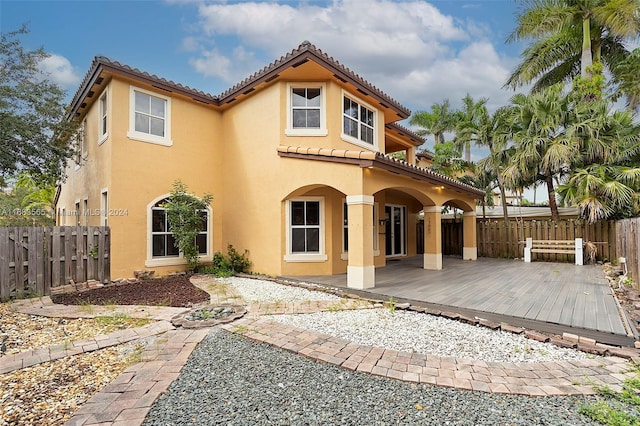 back of property featuring a patio area and a wooden deck