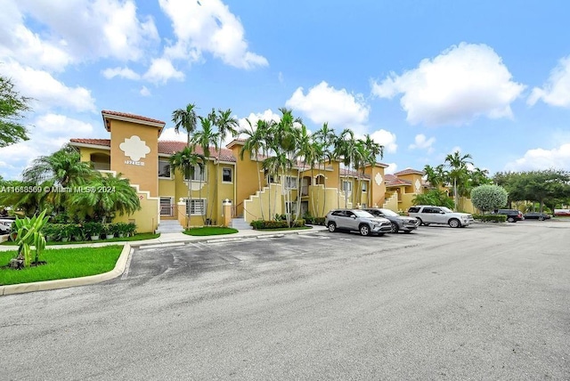 view of property featuring a residential view, uncovered parking, and stairs