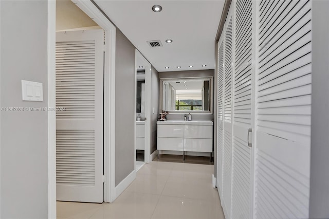 corridor featuring sink and light tile patterned floors