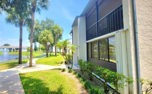 view of home's exterior featuring a water view and a yard