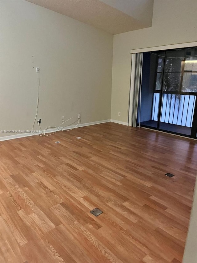 empty room with hardwood / wood-style floors and a textured ceiling