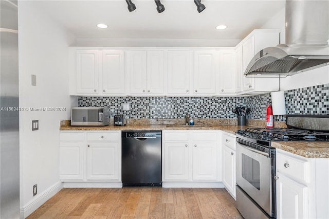 kitchen featuring appliances with stainless steel finishes, wall chimney exhaust hood, white cabinetry, and light hardwood / wood-style flooring