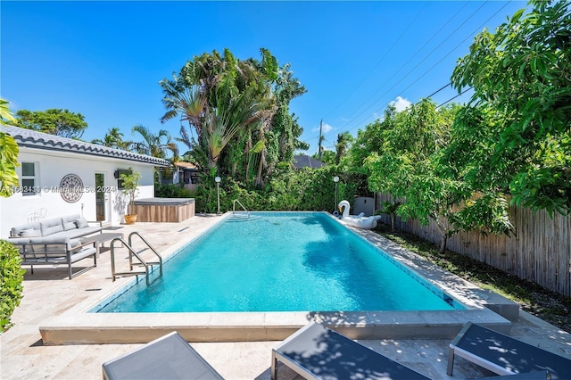 view of swimming pool featuring a patio area and a hot tub