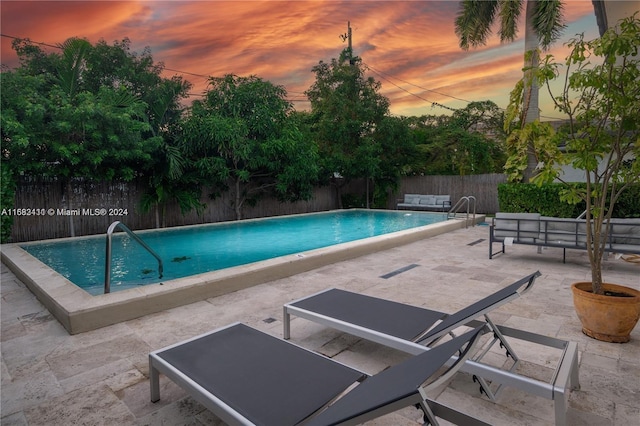 pool at dusk with a patio