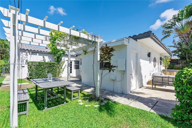 rear view of property featuring a pergola, a patio area, and a lawn