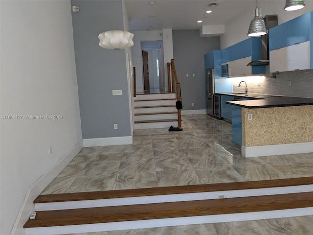 kitchen with blue cabinetry, tasteful backsplash, and decorative light fixtures