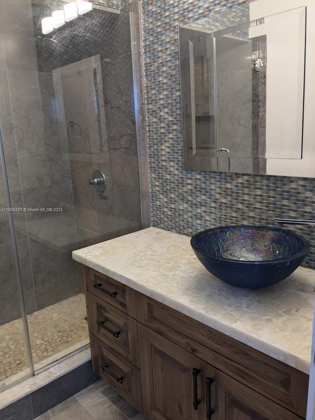 bathroom featuring vanity, decorative backsplash, a shower with shower door, and tile walls