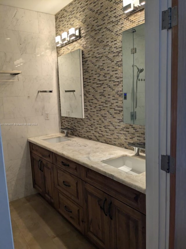 bathroom featuring vanity, decorative backsplash, tile walls, and tiled shower