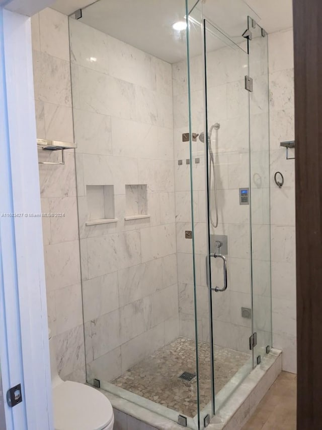 bathroom featuring toilet, walk in shower, and tile patterned floors