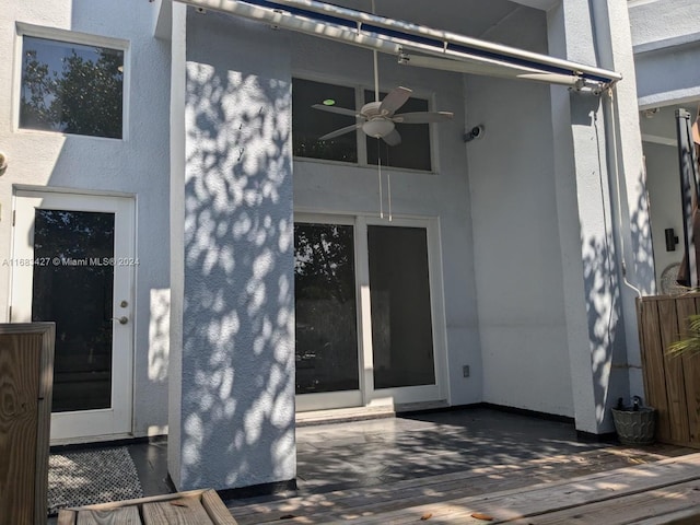 entrance to property with a wooden deck and ceiling fan