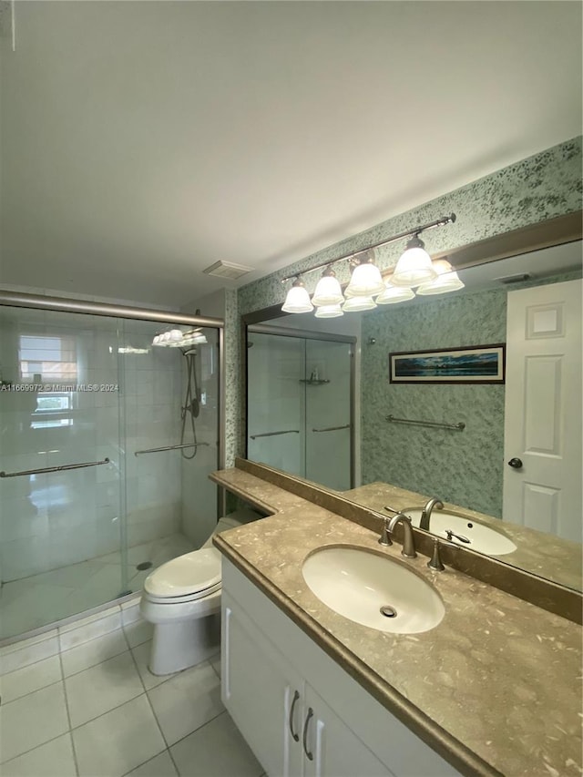 bathroom featuring vanity, a shower with shower door, toilet, and tile patterned flooring