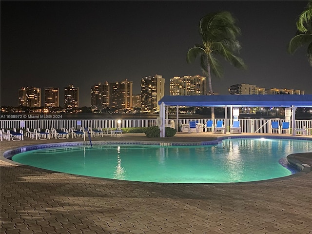 pool at twilight featuring a patio area