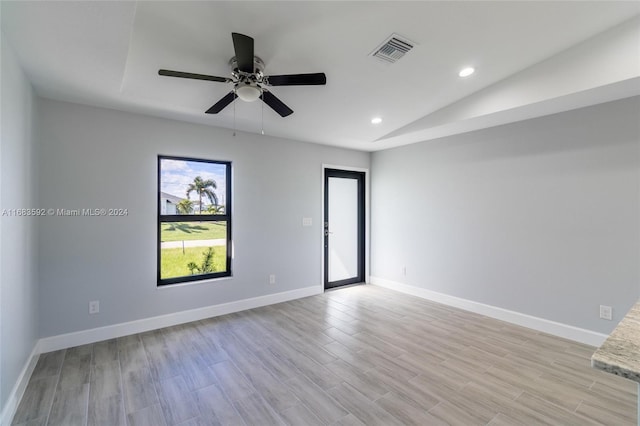 unfurnished room featuring lofted ceiling, light wood-type flooring, and ceiling fan