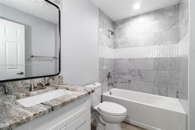 full bathroom with vanity, toilet, hardwood / wood-style floors, and tiled shower / bath